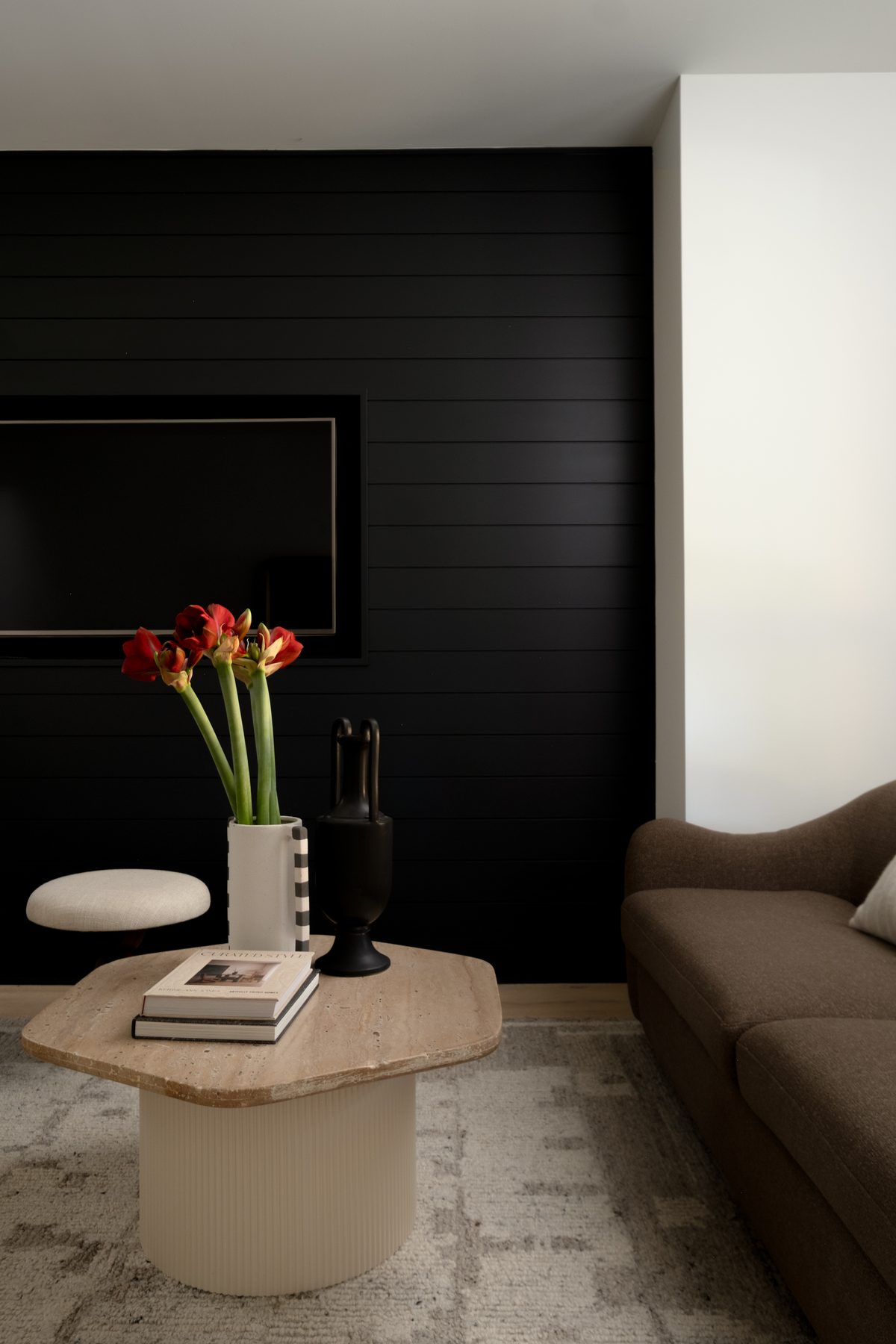 Living room with black panelled wall and red amaryllis